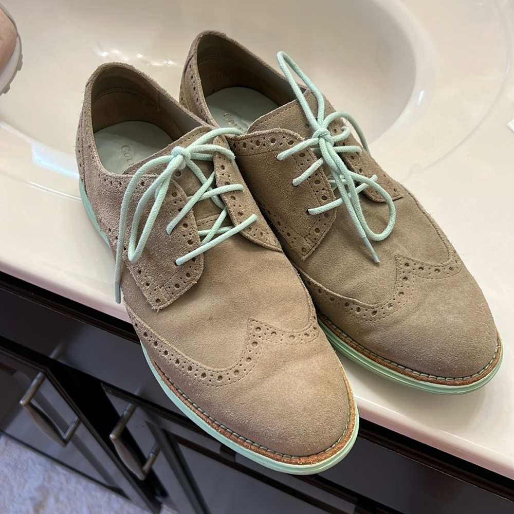 Cole Haan tan shoes with light green shoelaces.